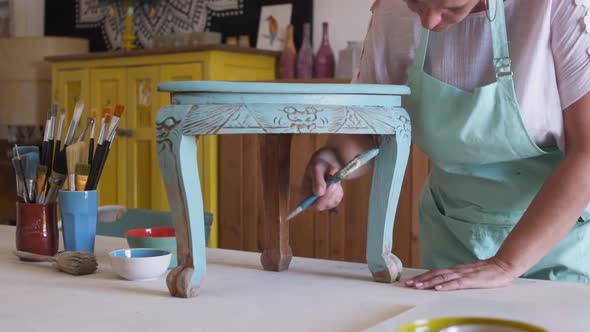 Professional Craftswoman Working and Painting Furniture in Home Improvement Workshop
