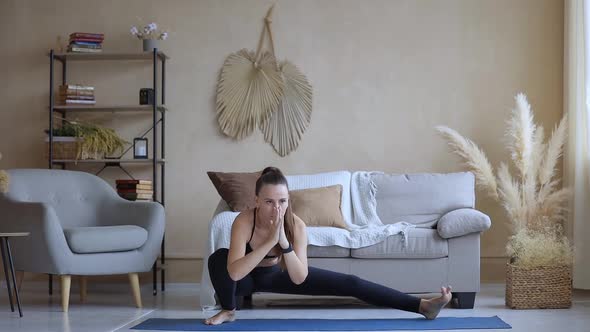Young Fitness Woman Practicing Yoga at Home in the Morning