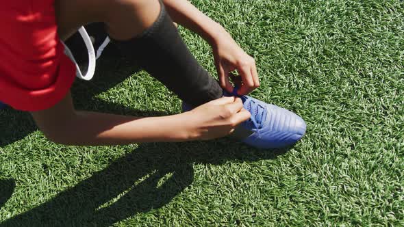 African American soccer kid lacing up his shoe alt