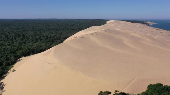 Group of People at the summit of Dune du Pilat in Arcachon Bassin France, Aerial close in shot alt