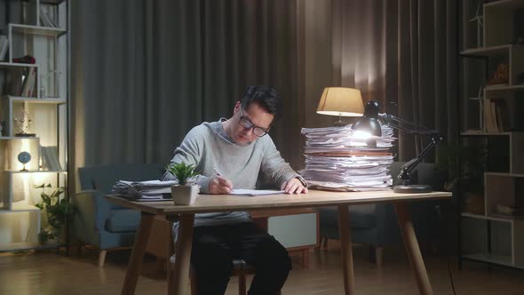 Asian Man Working With Documents At The Home alt