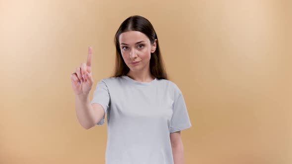 Young Caucasian Woman Over Plain Beige Background Showing Attention Sign with Pointed Finger Beige alt