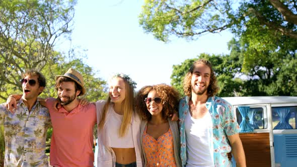 Portrait of happy hipster friends standing with arm around alt