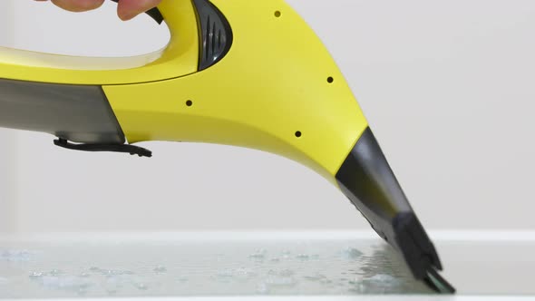 Cleaning the House Handheld Window Vacuum Cleaner Cleaning Glass Closeup alt