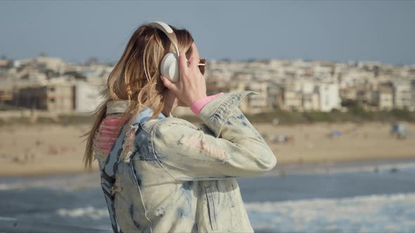 Blonde Woman with Wearing Wireless Headphones Listening Music Enjoying Sunset alt