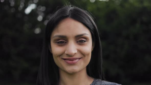 Happy Indian girl looking at camera outdoor alt