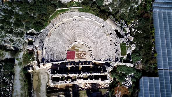 High angle drone aerial view of ancient greek rock cut lykian empire amphitheatre and tombs in Myra alt