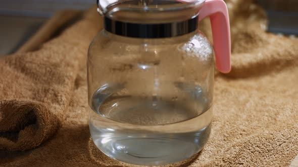 Pouring Tea Leaves and Flowers in a Transparent Mug with Hot Water alt