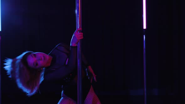 Young Hot Woman in Tights with a Large Mesh Dances Performs Some Pole Dance Elements Near Pole
