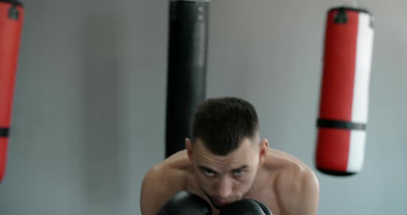 Kickboxer in Boxing Gloves Does Shadow Boxing and Trains at Boxing Club Fighter Man is Fighting with alt