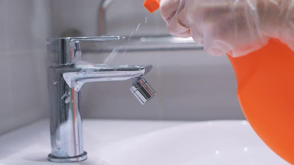 Woman's Gloved Hand Washes the Faucet in the Bathroom, Close-up, Slow Motion. Cleaning the Bathroom alt