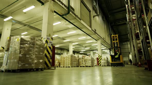 Forklift Rides on in Logistic Warehouse with Pallet. Logistic Warehouse