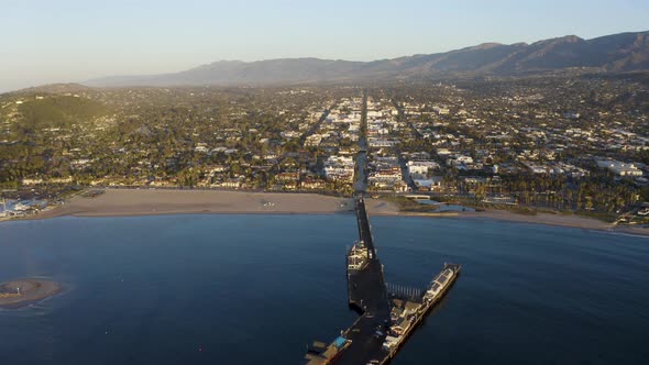 Ocean harbor pier looking toward town beach city and mountains in background 4k Prores alt