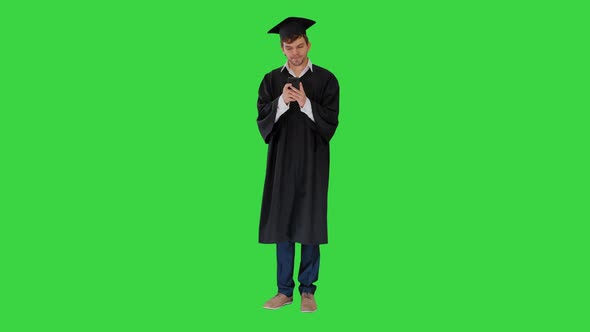 Graduate Student Texting Message on the Phone on a Green Screen, Chroma Key. alt