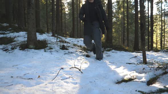 Low Angle View of Young Hiker Walking Towards Camera in Mountain Forest at Sunny Day alt