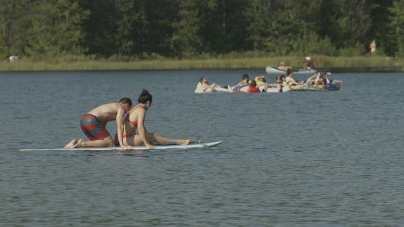 Couple on a paddleboard on a lake alt