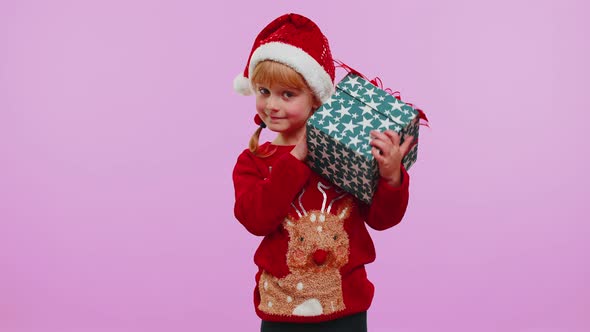Funny Toddler Child Girl Wears New Year Sweater Received Present Interested in What Inside Gift Box alt