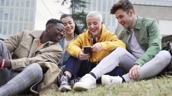 Happy University Student Friends Having Fun Sharing Moments on Smartphone App Sitting on the Campus alt