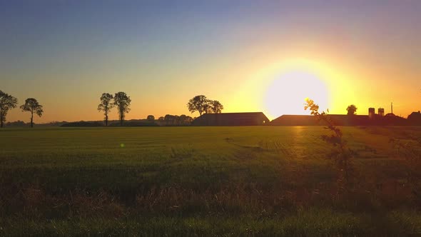 Aerial Cinematic Clip Drone Flying Over a Farm Field During Sunset alt