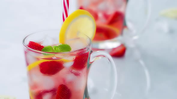 Cold refreshing strawberry lemonade juice drinks with ice cubes