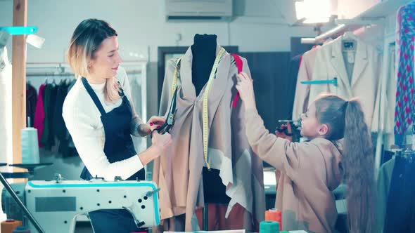 A Dressmaker and a Girl are Working with Fabric Together alt