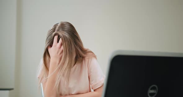 Young Woman Laughs Sitting at Black Laptop at Online Date alt