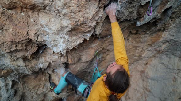 Aerial Cinematic Slow Motion of Strong Skilful Man Rock Climber Climbs on Overhanging Rock Cliff alt