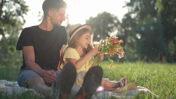 Happy Relaxed Girl Talking Sitting with Young Man in Sunbeam Enjoying Family Weekend alt