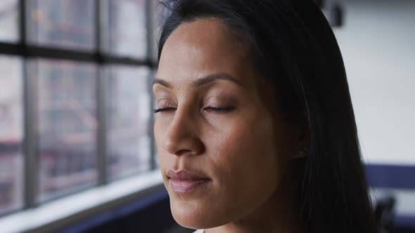 Portrait close up of mixed race businesswoman looking at camera and smiling in office alt