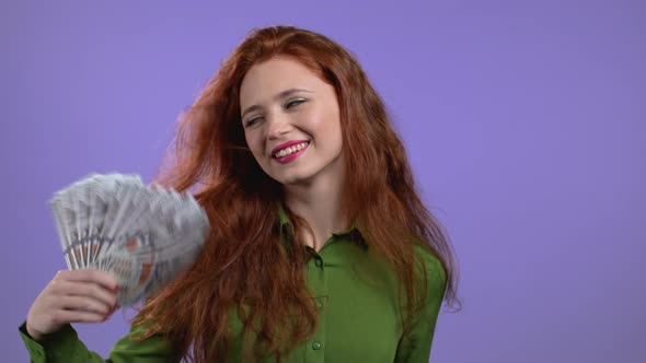 Smiling Happy Woman with Cash Money  USD Currency Dollars Banknotes on Violet Wall alt