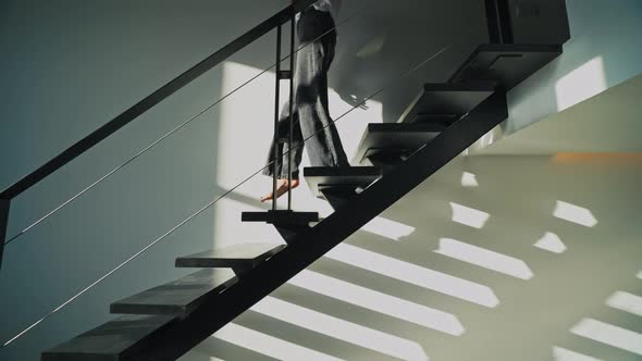 A Woman Descends the Stairs of the Second Floor of the Apartment at Dawn