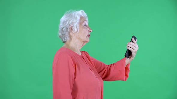 Portrait Elderly Woman Talking on a Video Call Using Her Smartphone alt