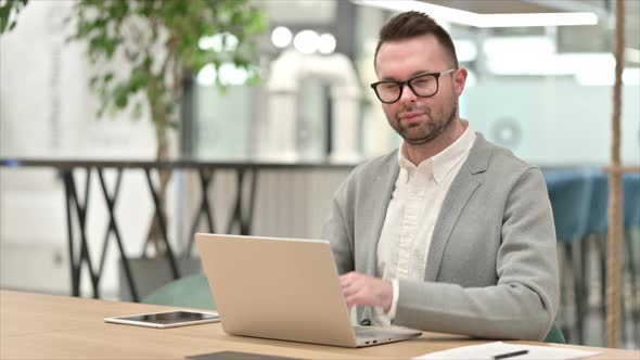 Creative Man with Laptop Saying No with Finger Sign alt