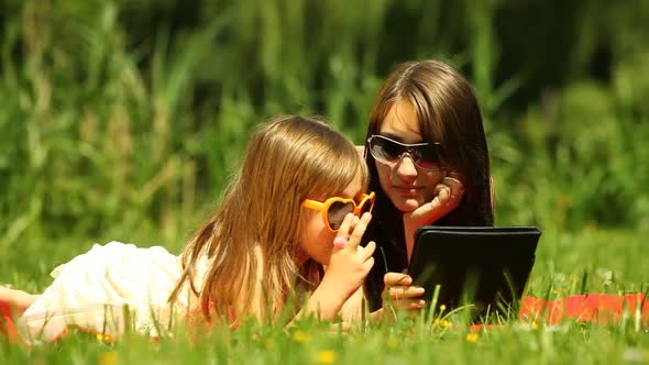 Picnic. Mother With Daughter Using Tablet Outdoor alt