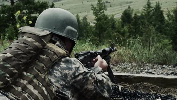 Soldier with a belt-fed machine gun. He pulls back on a lever on the firearm and pushes it back. alt