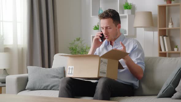 Man Sitting on Sofa with Opened Parcel Express Complaints to Seller or Courier on the Phone About alt