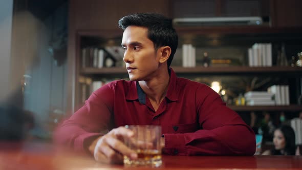 4K Asian man enjoy hangout nightlife drinking whiskey at luxury bar alt