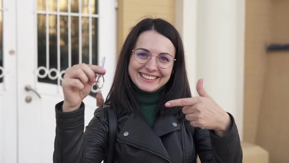 The girl holds the keys to a new apartment. The concept of buying a new apartment. Slow motion. alt