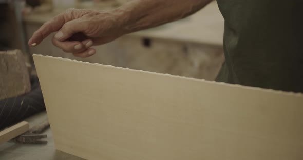 older hands smearing glue on wood