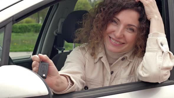 Successful Beautiful Happy Woman in the New Car with Keys