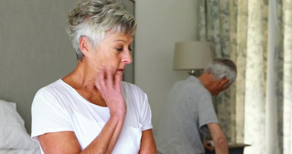 Upset senior couple arguing with each other in bedroom alt
