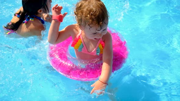 A Child Swims in a Pool with a Circle alt