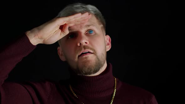 Man in Stylish Blouse Looks Around with His Hand on His Forehead Waving Hand Hi Hello Welcome Bye alt