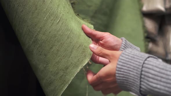 Female Hands Touch The Burlap Fabric. Roll Of Fabric Rough Texture Hands Hold The Fabric alt