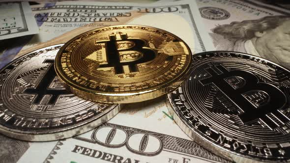 Cryptocurrency Bitcoins in silver and gold coins stacked on 100 dollar bills alt