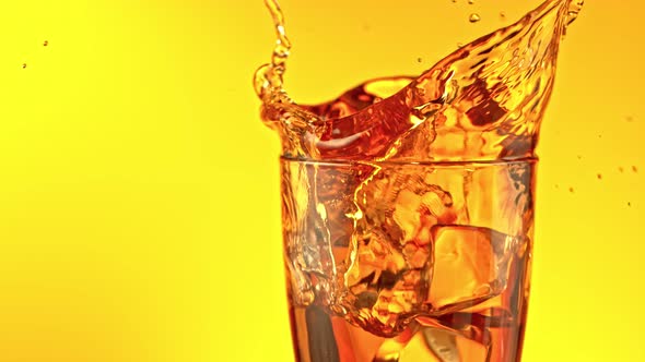 Super Slow Motion Shot of Ice Cubes Falling Into Glass of Ice Tea and Making Splash at 1000 Fps alt
