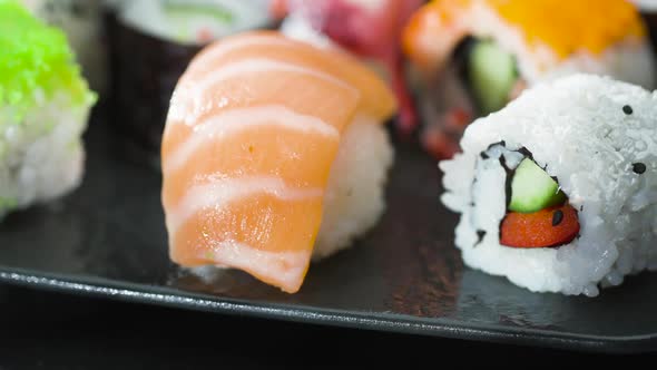 Sushi and Maki Made from Fresh Seafood and Vegetables on a Plate in a Japanese Restaurant. alt