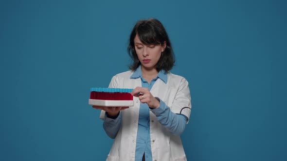 Microbiology Specialist Looking at Test Tubes with Liquid Samples alt