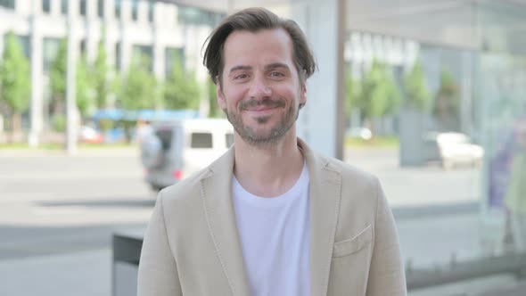 Outdoor Portrait of Agree Young Man Shaking Head in Approval alt