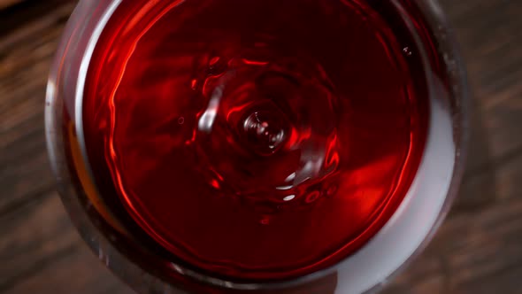 Super Slow Motion Macro Shot of Dripping Droplet Into Filled Glass of Red Wine at 1000Fps alt